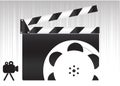 Black movie clapperboard and camera icon on gray background